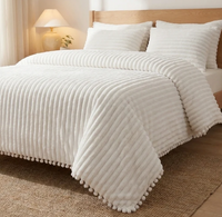 Cloudline comforter with pom-pom trim on a bed